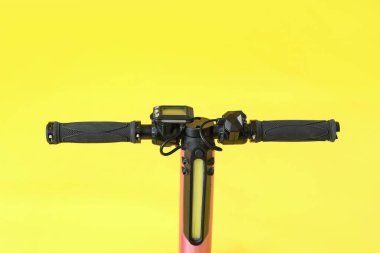 Sarı arka planda modern elektrikli scooter, yakın plan.