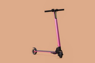 Kahverengi arka planda pembe modern elektrikli scooter.