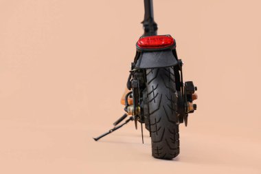 Kahverengi arka planda modern elektrikli scooter, yakın plan.