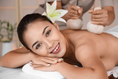 Çiçekli genç Asyalı kadın spa salonunda masaj yaptırıyor, yakın plan.