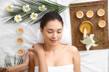 Genç Asyalı kadın güzellik salonunda masaj yaptırıyor.