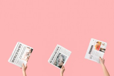Pembe arka planda gazeteleri olan kadınlar