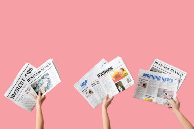 Pembe arka planda gazeteleri olan kadınlar