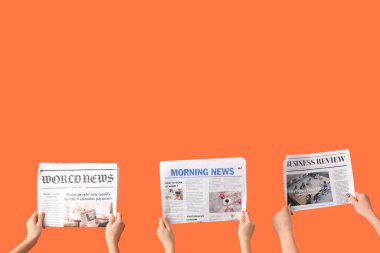 Turuncu arka planda gazeteleri olan kadınlar