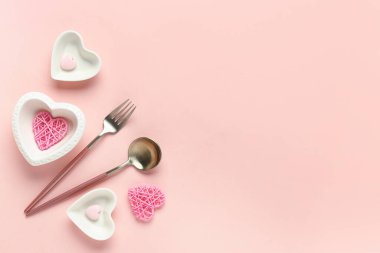 Pembe arka planda kupa şeklinde kâselerle güzel bir masa. Sevgililer Günü kutlaması