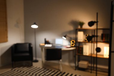 Ofisin bulanık görüntüsü, iş yeri ve gece lambaları.