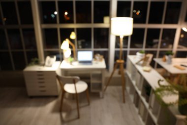 Ofisin bulanık görüntüsü, iş yeri ve gece lambaları.