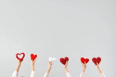 Beyaz arka planda farklı kalpleri tutan kadın elleri. Sevgililer Günü kutlaması