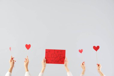 Kağıt kalp tutan kadın eller ve beyaz arka planda 