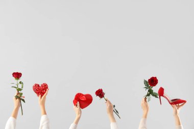 Beyaz arka planda sevgililer günü kutlaması için gül ve farklı hediyeler tutan kadın eller.