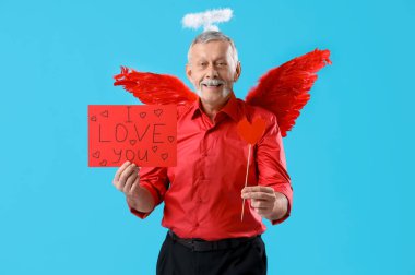 Aşk tanrısı gibi giyinmiş olgun bir adam elinde 