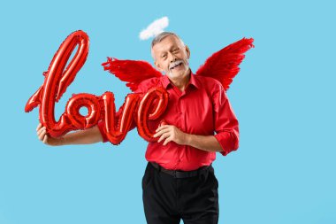 Aşk tanrısı gibi giyinmiş, mavi arka planda balonlardan yapılmış bir aşk sözcüğü. Sevgililer Günü kutlaması