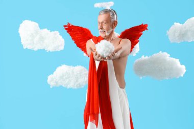 Mavi arka planda bulutlar içinde Aşk Tanrısı gibi giyinmiş olgun bir adam. Sevgililer Günü kutlaması