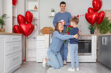 Küçük çocuk Sevgililer Günü 'nde annesini güllerle selamlıyor.