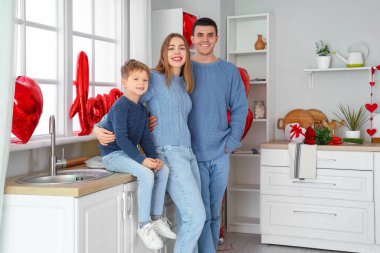 Sevgililer Günü 'nde ailesiyle mutfakta kucaklaşan küçük bir çocuk.