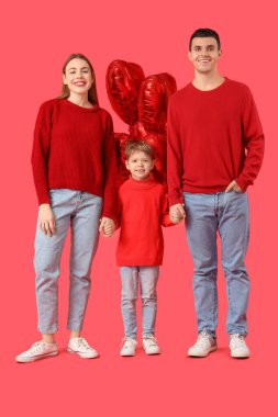 Kırmızı arka planda ailesi el ele tutuşan ve balonları olan küçük bir çocuk. Sevgililer Günü kutlaması