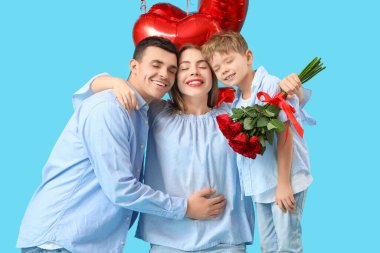 Ailesi mavi arka planda sarılan küçük bir çocuk. Sevgililer Günü kutlaması