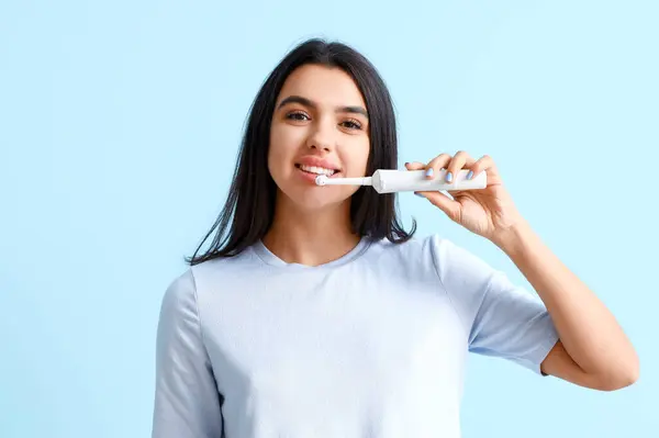 Smiling Young Woman Electric Toothbrush Blue Background — Stock Photo, Image