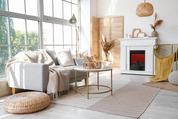 Gri kanepesi, sehpası ve şöminesi olan aydınlık oturma odasının içinde.