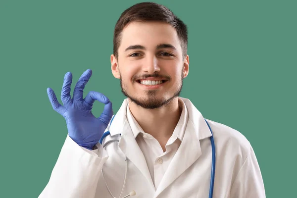 Junger Zahnarzt Mit Gesunden Zähnen Mit Geste Auf Grünem Hintergrund — Stockfoto