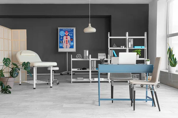 Çalışma yeri, kanepesi ve raf ünitesi olan modern tıp bürosu.