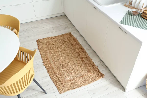 Modern mutfağın içinde şık bir hasır halı var.