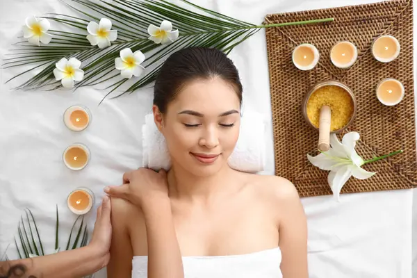 Genç Asyalı kadın güzellik salonunda masaj yaptırıyor.