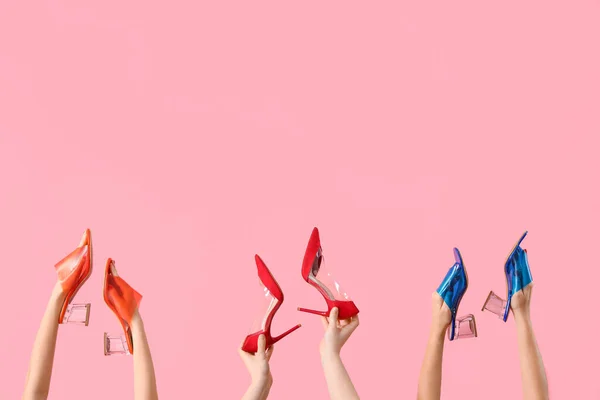 Manos Femeninas Sosteniendo Diferentes Zapatos Tacón Alto Sobre Fondo Rosa —  Fotos de Stock
