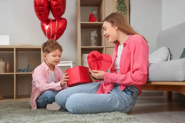 Sevgililer Günü 'nde annesiyle küçük bir çocuk evde hediye kutusu açıyor.