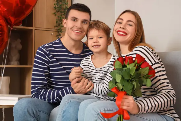 Sevgililer Günü 'nde ailesi ve gülleriyle evde kucaklaşan küçük çocuk.