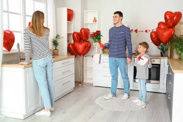 Sevgililer Günü 'nde babasıyla küçük bir çocuk mutfakta annesini selamlıyor.