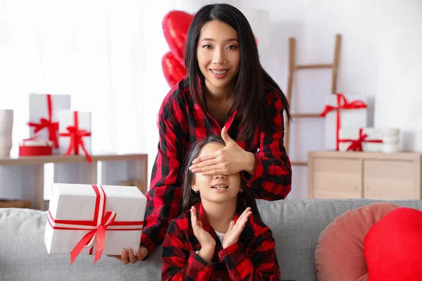 Young Asian woman greeting her little daughter with Valentine\'s day at home