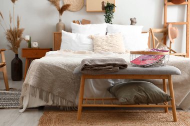 Şık bir yatak odası, rahat bir yatak odası ve yatağın yanında bir bank.