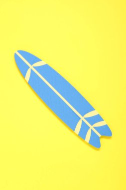 Sarı arka planda mini sörf tahtası