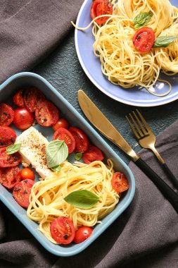 Domatesli lezzetli makarna ve mavi arka planda beyaz peynir.