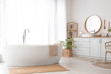 Lavabosu, aksesuarı ve küveti olan bir banyo.