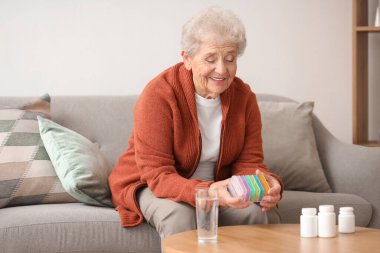 Evde hap kutusu olan son sınıf öğrencisi bir kadın.