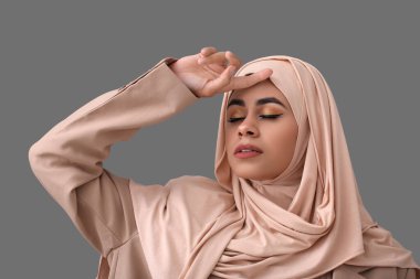 Gri arkaplanda güzel makyajlı Afro-Amerikan genç bir kadın.