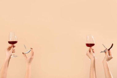 Bej arka planda şarap bardakları ve tirbuşonu olan kadınlar. Sevgililer Günü kutlaması