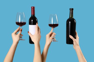 Mavi arka planda şişe ve şarap kadehleri olan kadınlar. Sevgililer Günü kutlaması