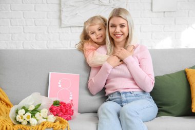 Evde annesine sarılan küçük bir kız. Uluslararası Kadınlar Günü kutlamaları