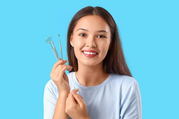 笑顔の若いアジアの女性と青い背景に歯科ツール クローズアップ — ストック写真