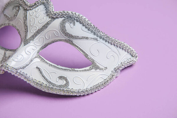 Белая карнавальная маска на сиреневом фоне