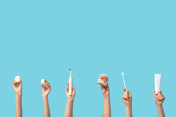Weibliche Hände Mit Dentalmodellen Und Mundhygieneartikeln Auf Blauem Hintergrund — Stockfoto