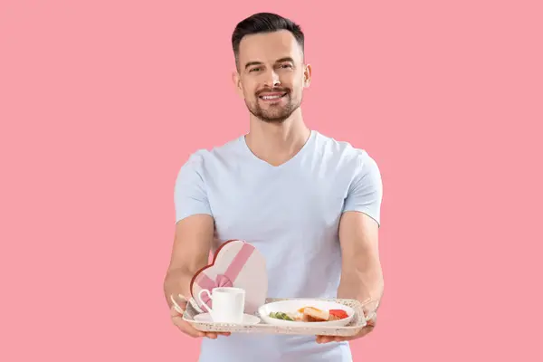 Junger Mann Mit Leckerem Frühstück Und Geschenkbox Auf Rosa Hintergrund — Stockfoto