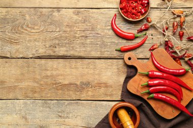 Kahverengi ahşap zemin üzerinde havan topu olan taze ve kuru kırmızı biber panosu.