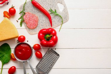 Açık ahşap arka planda pizza hazırlamak için farklı malzemeler.