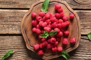 Ahşap zemin üzerinde taze ahududu ve nane aromalı pano.