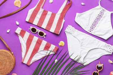 Plaj aksesuarları ve mor arka planda palmiye yaprağı olan kompozisyon