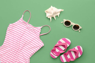 Yeşil arka planda plaj aksesuarları olan kompozisyon